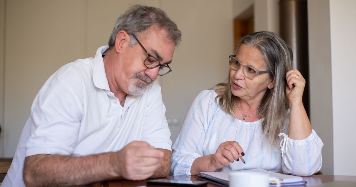 Older couple reviewing paperwork together at a table at home