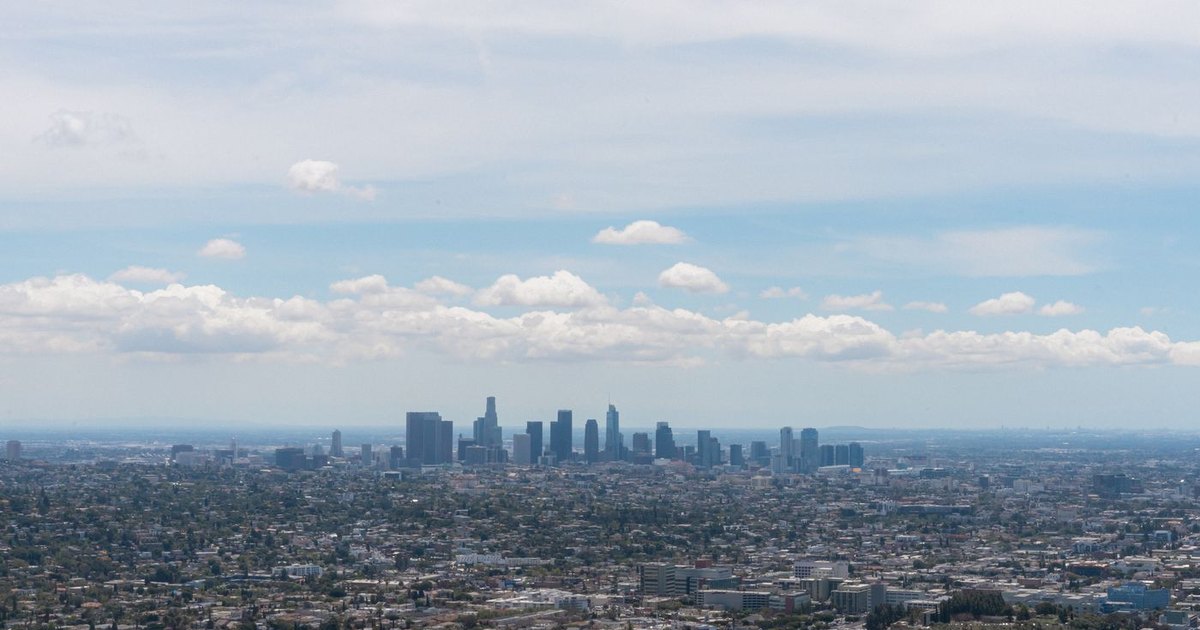 Wide view across the Los Angeles basin toward the downtown skyline under a partly cloudy sky