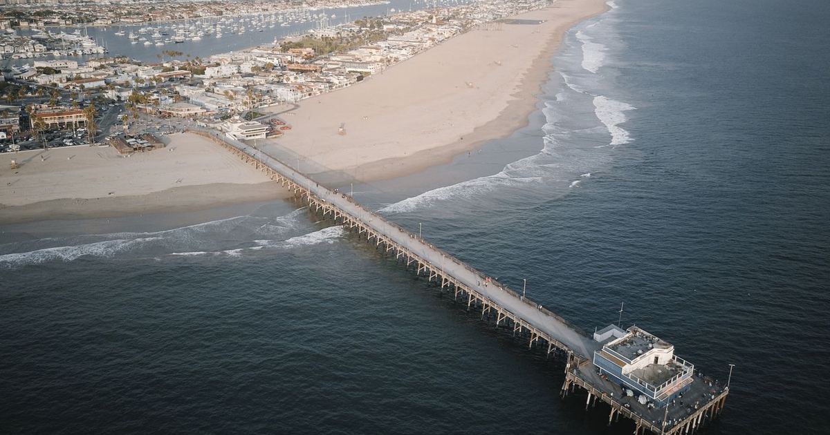 Aerial view of the Newport Beach Pier and Balboa Peninsula shoreline in Orange County
