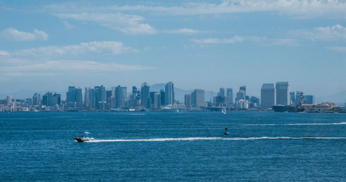 San Diego downtown skyline seen across the bay on a clear day, with a boat crossing the water